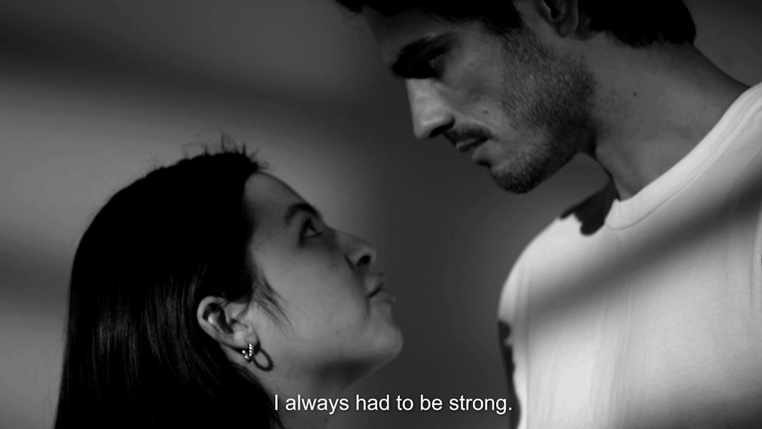 A woman and a man talking. The subtitle reads, 'I always had to be strong.'